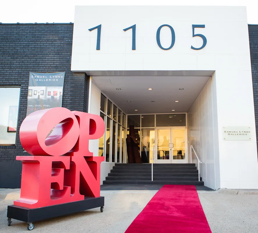 Samuel Lynne Galleries entrance at 1105 Dragon Street, Dallas, with a red OPEN sculpture and red carpet leading to the gallery doors